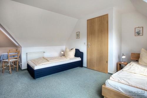 ツィングストにあるOstseewelle Whg 7のベッドルーム1室(ベッド2台、椅子付)