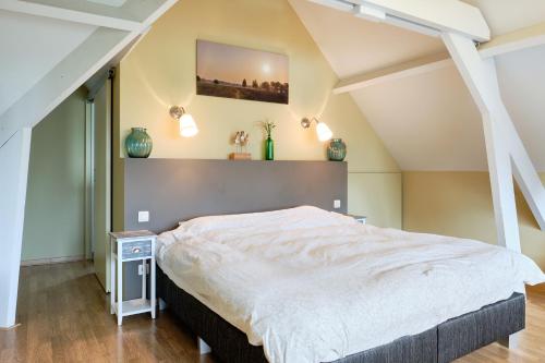 ein Schlafzimmer mit einem großen Bett im Dachgeschoss in der Unterkunft Pieters Huis in Kinrooi