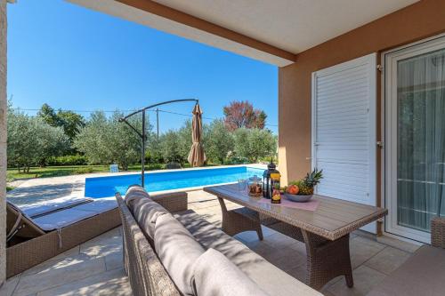 a patio with a couch and a table next to a pool at Villa Terlevic in Selina