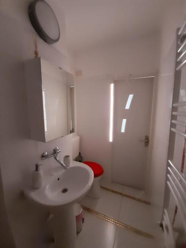 a white bathroom with a sink and a toilet at 2 rooms apartment Telecabinei Busteni in Buşteni