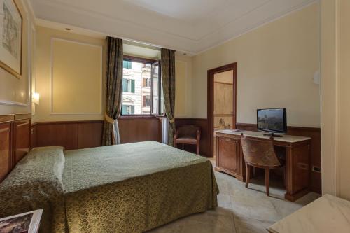 sypialnia z łóżkiem, biurkiem i telewizorem w obiekcie Hotel Borromeo w Rzymie