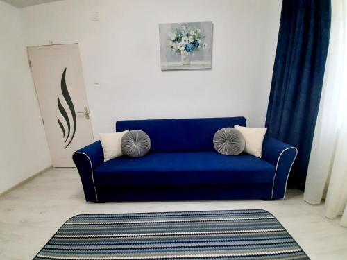 a blue couch with two pillows in a living room at 2 rooms apartment Telecabinei Busteni in Buşteni