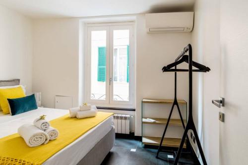 a bedroom with a bed with a yellow blanket and a window at Ravecca Luxury apartment - near Columbus house in Genova