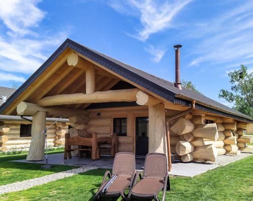 una cabaña de madera con sillas delante en Naturstammhaus Tollensesee, en Krickow