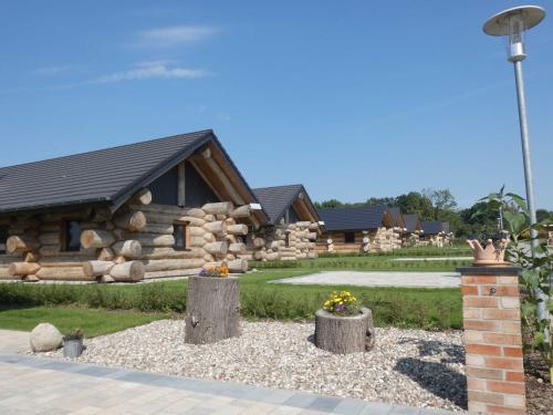 a log cabin with some flowers in front of it at Naturstammhaus Tollensesee in Krickow