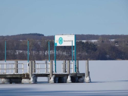 a sign on a pier next to a body of water at Naturstammhaus Tollensesee in Krickow