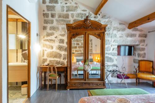 a bedroom with a mirror and a stone wall at Auberge U n'Antru Versu in San-Gavino-di-Carbini