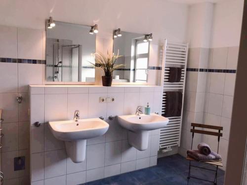 a bathroom with two sinks and a mirror at Ferienwohnung Möwe in Heiligenhafen