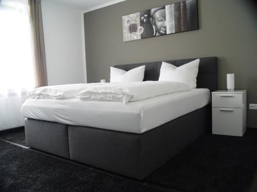 um quarto com uma cama grande com lençóis brancos e almofadas em La Domus Superior em Lotte