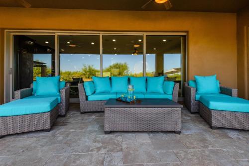 a patio with blue couches and a table at Casa Cielo home in Scottsdale