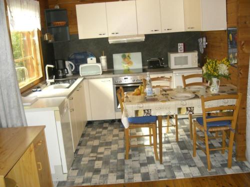 a kitchen with white cabinets and a table and chairs at Ferienwohnung Dehnsen in Amelinghausen