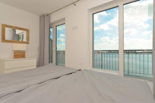 a bedroom with a bed and a large window at Marina Villa in Kappeln