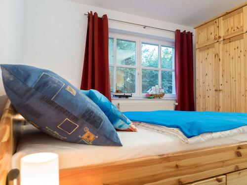 a bedroom with a bed with blue pillows on it at Kranichrast 1 Whg 2 in Zingst