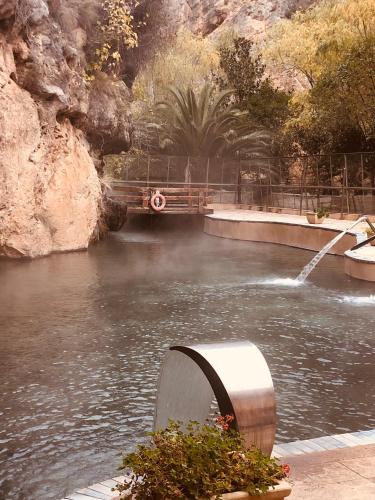a body of water with a fountain in the middle at Hotel Balneario de La Virgen in Jaraba