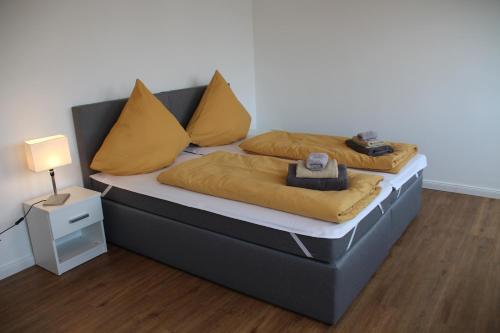 ein Schlafzimmer mit 2 Betten mit gelben Kissen und einer Lampe in der Unterkunft Casa Kronengarten Nr 7 in Hilden