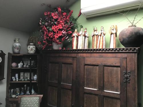 a wooden cabinet with a group of statues on top of it at Art House in Huonville