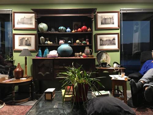 a room with a shelf filled with lots of vases at Art House in Huonville