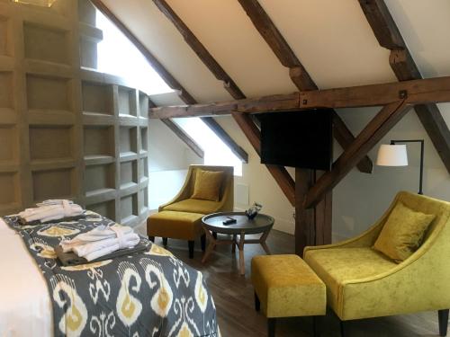 a bedroom with a bed and two chairs and a tv at Hotel 1622 - Spa, Hotell & Konferens in Helsingborg