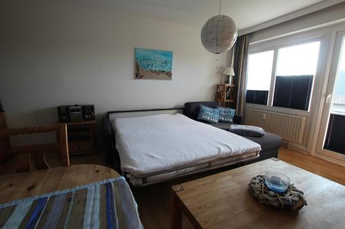 ein Wohnzimmer mit einem Bett und einem Tisch in der Unterkunft MPH - Whg 14 in Wyk auf Föhr