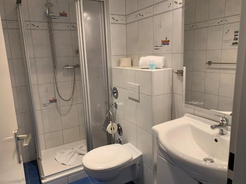 ein Bad mit einer Dusche, einem WC und einem Waschbecken in der Unterkunft MPH - Whg 14 in Wyk auf Föhr