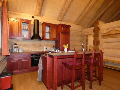 a kitchen with a center island in a log cabin at Naturstammhaus Tollensesee in Krickow