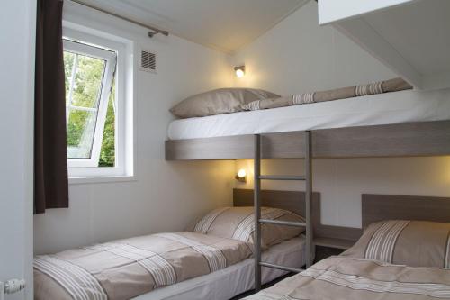 Ce dortoir comprend 2 lits superposés et une fenêtre. dans l'établissement Chalet bis 5 Personen ohne Hund, à Norden