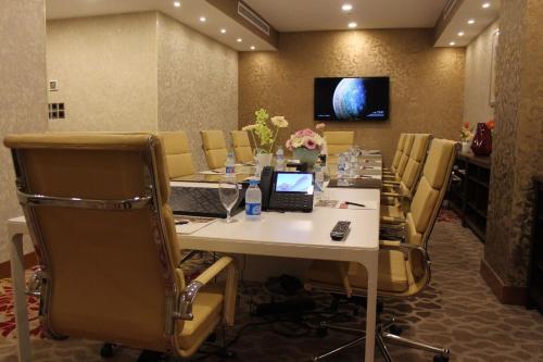 a conference room with a long table with a laptop at Velvet Hotel Jeddah in Jeddah