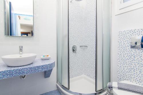 La salle de bains est pourvue d'une douche et d'un lavabo. dans l'établissement White & Blue, à Perivolos
