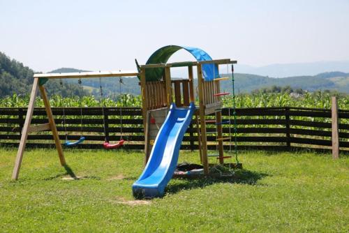 un parque infantil con un tobogán en el césped en Pensiunea Rosia, en Roşia