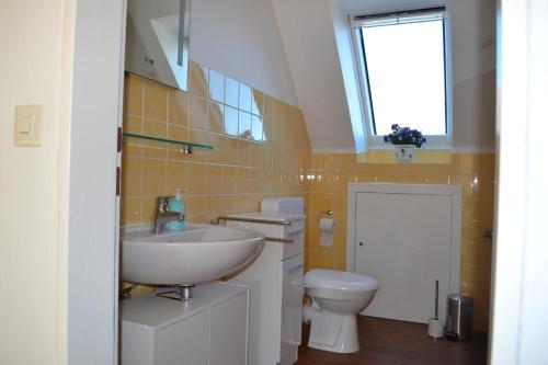 ein Bad mit einem Waschbecken und einem WC in der Unterkunft Cantay-Mathildenstraße 16 - FW 4 - OG rechts in Fehmarn