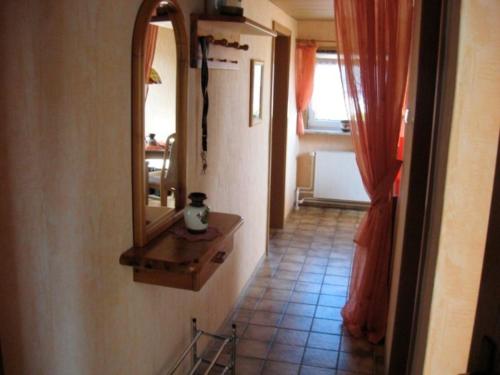 a hallway with a mirror and a tile floor at Haus Monika in Büdelsdorf