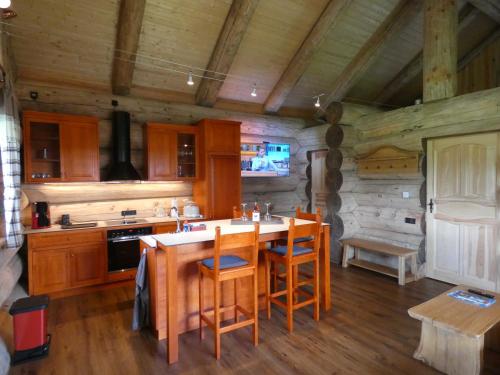 a kitchen with a table and chairs in a cabin at Naturstammhaus Tollensesee in Krickow