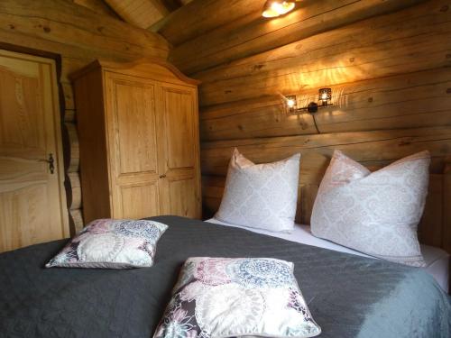 a bedroom with a bed in a wooden cabin at Naturstammhaus Tollensesee in Krickow