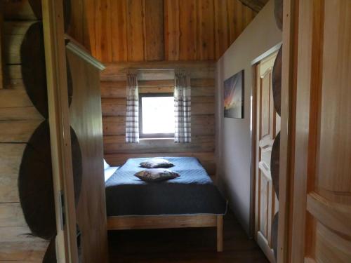 a small room with a bed in a cabin at Naturstammhaus Tollensesee in Krickow
