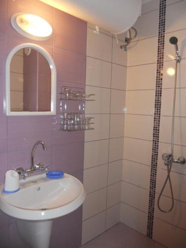 uma casa de banho com um lavatório e um chuveiro em Стаи под наем "Таня"- безплатен паркинг на 100 метра em Ahtopol