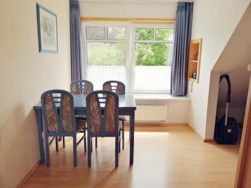 einen Esstisch mit Stühlen und ein Fenster in der Unterkunft Seerose - 2092 in Bünsdorf