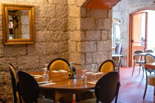 a dining room table with a glass of wine on it at Auberge U n'Antru Versu in San-Gavino-di-Carbini