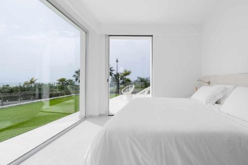 een slaapkamer met een wit bed en een groot raam bij KARAT Villa Abama - DAILY MAID SERVICE in Tejina de Isora