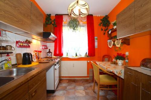a kitchen with orange walls and a table and a window at Private Rooms in Hannover