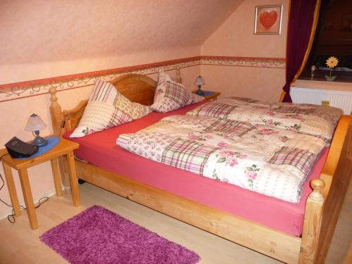 a bedroom with a wooden bed and a purple rug at Ferienwohnung PANTEN in Neukirchen