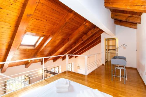 an attic room with wooden ceilings and a staircase at Central&Lovely Savoia Loft in Turin