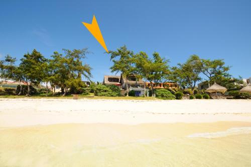 a yellow kite flying over a sandy beach at Studio Isabella in Palmar
