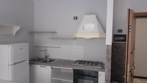 a white kitchen with a sink and a stove at La dolce vita (1) in Bergamo