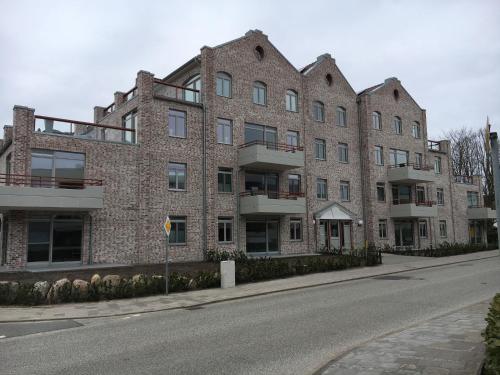 un grande edificio in mattoni sul lato di una strada di Komfort-Wohnung 03 FehmarnBrise a Burg auf Fehmarn