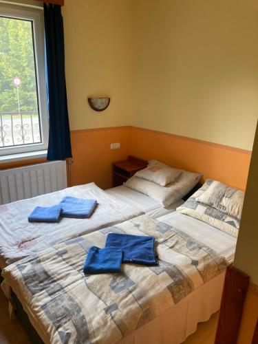 two beds in a room with blue towels on them at Bor-Bazilika-Vendégház in Tarcal