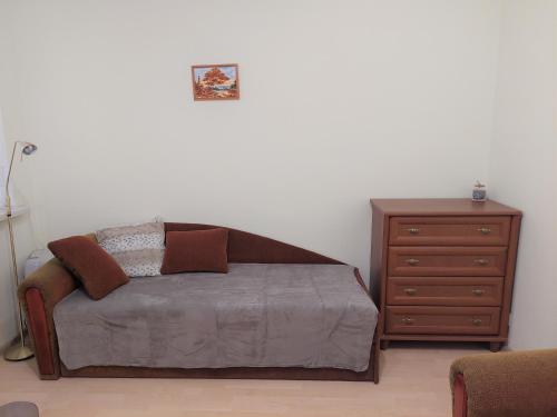 uma cama e uma cómoda num quarto com uma cama e uma mesa de cabeceira em Butas Palangoje em Palanga