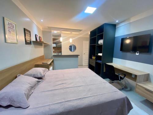 1 dormitorio con 1 cama grande y escritorio en Apartamento Studio Centro de Macapá en Macapá