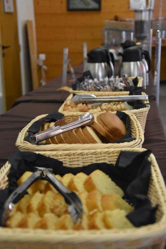 two baskets of bread and pastries on a table at Village club de Bois d'Amont in Bois-dʼAmont