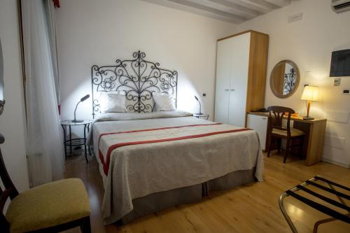 a bedroom with a large bed and a chair at Hotel Antigo Trovatore in Venice