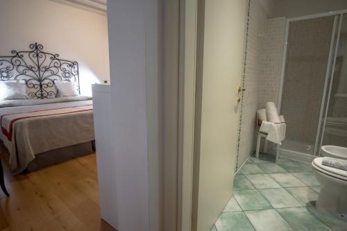 a bathroom with a bed and a toilet in a room at Hotel Antigo Trovatore in Venice